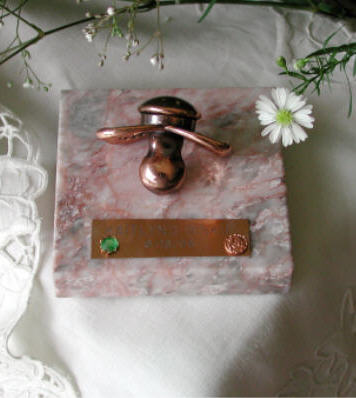 Bronzed pacifier on rose marble base